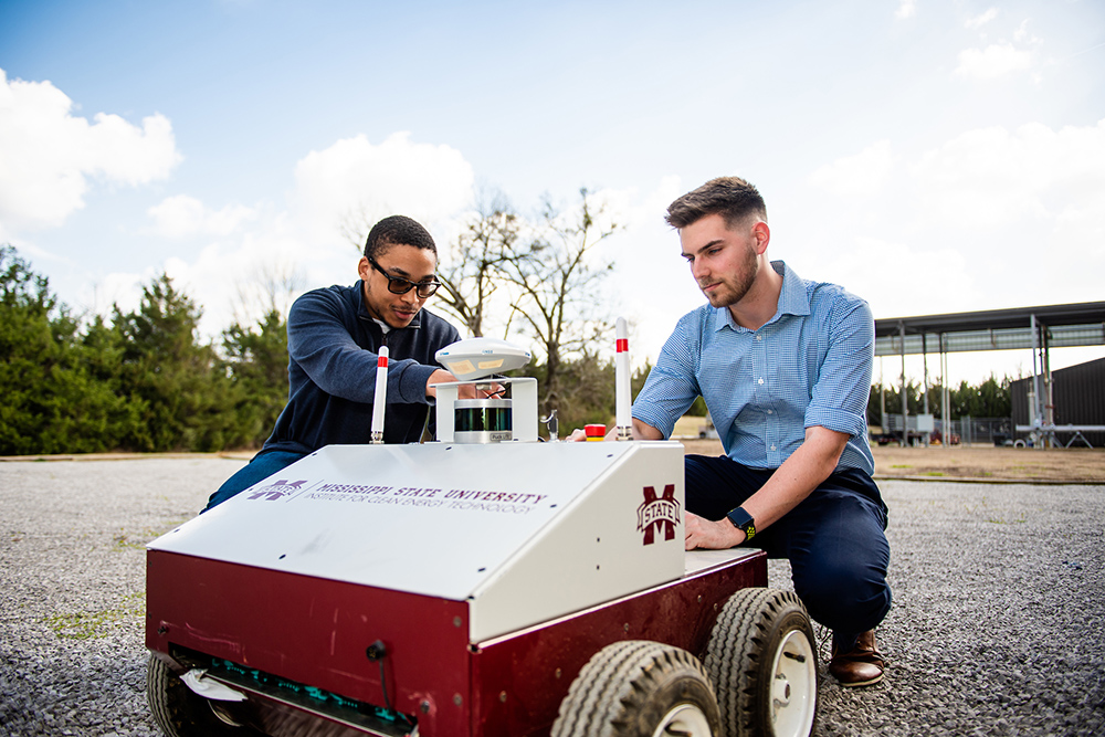 Two people looking at ICET Autonomous Robot