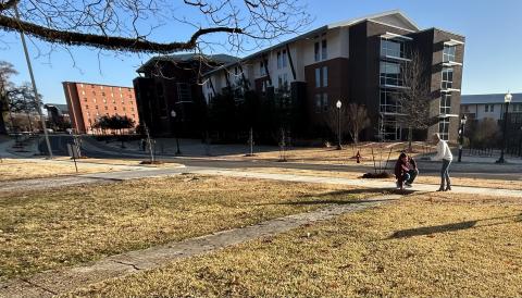 Image of two individuals taking a phot of an uneven sidewalk.